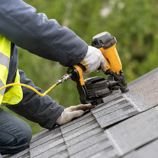 Roofer installs asphalt shingles.